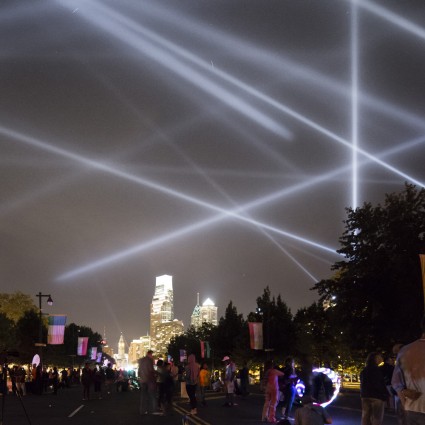 Participants along the Benjamin Franklin Parkway look out on "OPEN AIR" by Rafael Lozano-Hemmer from Eakins Oval