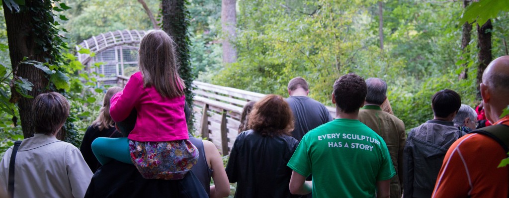 A group of people led by a Public Art Ambassador visit Martin Puryear's Pavilion in the Trees