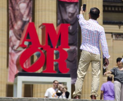 Tourists take photos of AMOR sculpture