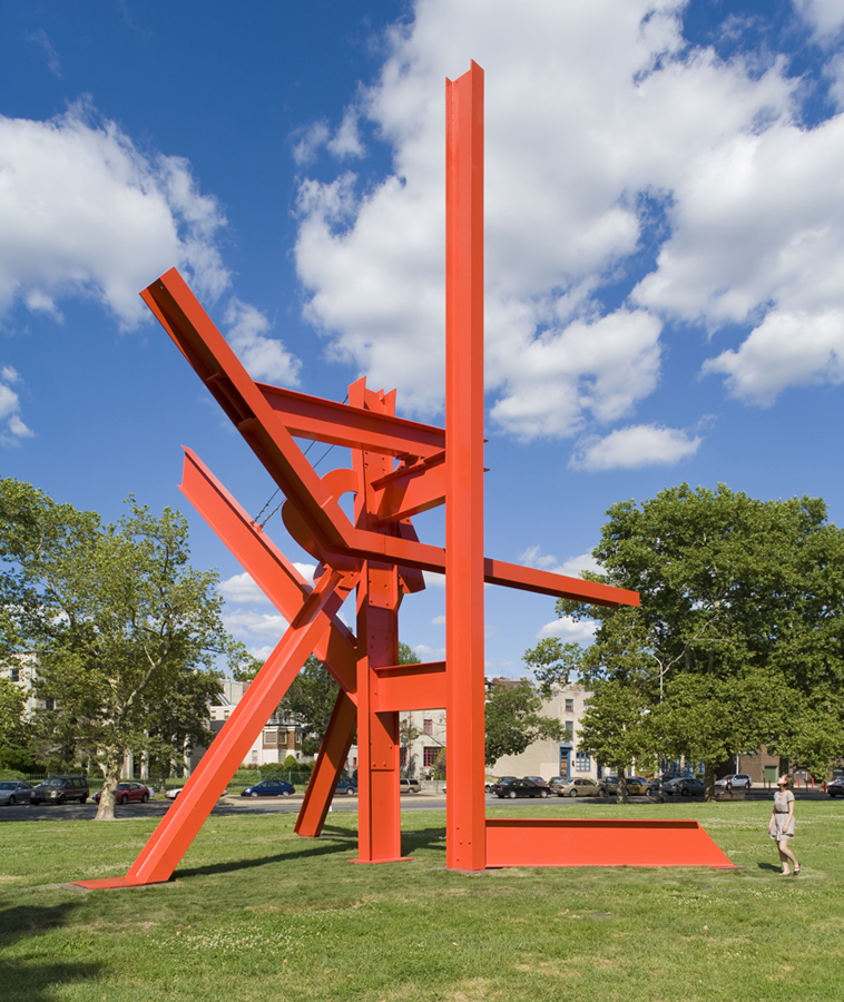 A woman walks by the monumental sculpture Iroquois by artist Mark di Suvero