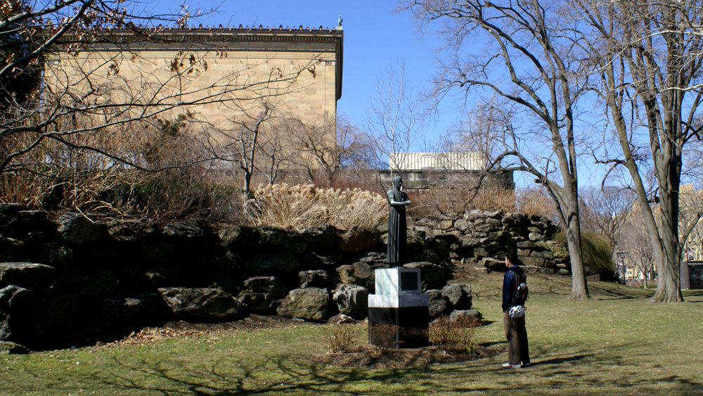 A man looks at Charioteer of Delphi outside of the Philadelphia Museum of Art