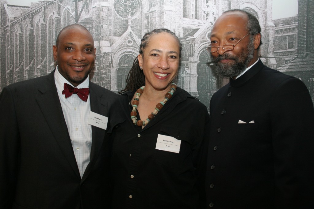 Artists John Stone, Lorene Cary and Lonnie Graham posing in front of a photo mural of the former St. Elizabeth's Church