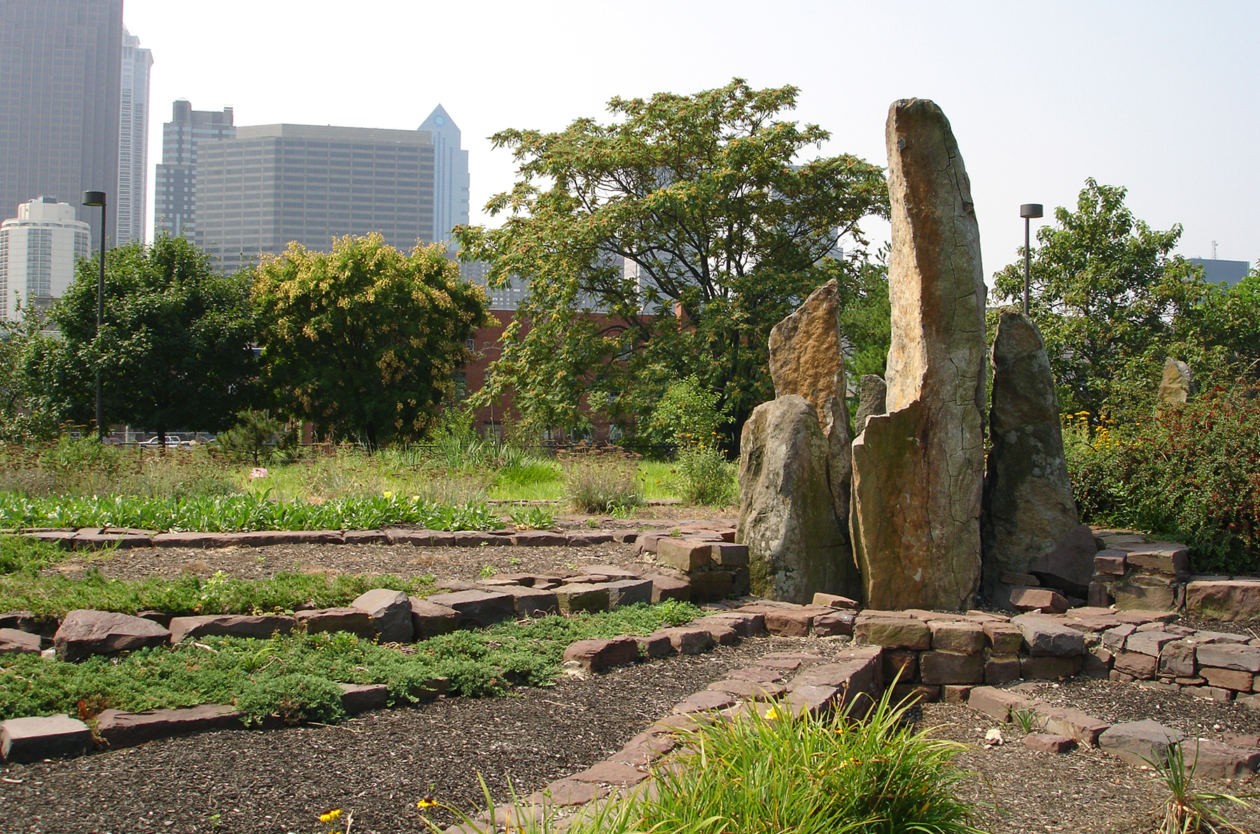 Two-acre sculptural landscape: large boulders, plantings, terraced gardens, paths, stones, trees