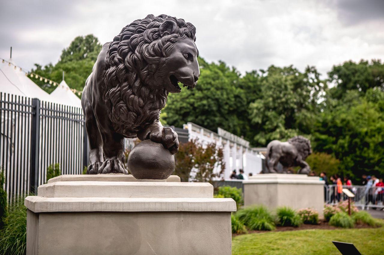 Two bronze lion sculptures at the main entrance of the Mann Center outdoors