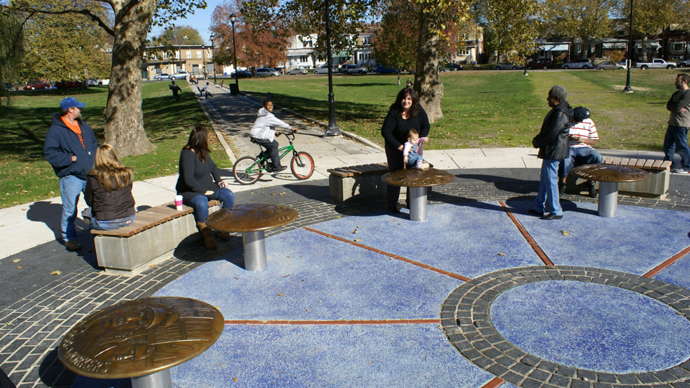People seated at John Kindness's Labor Monument in Elmwood Park