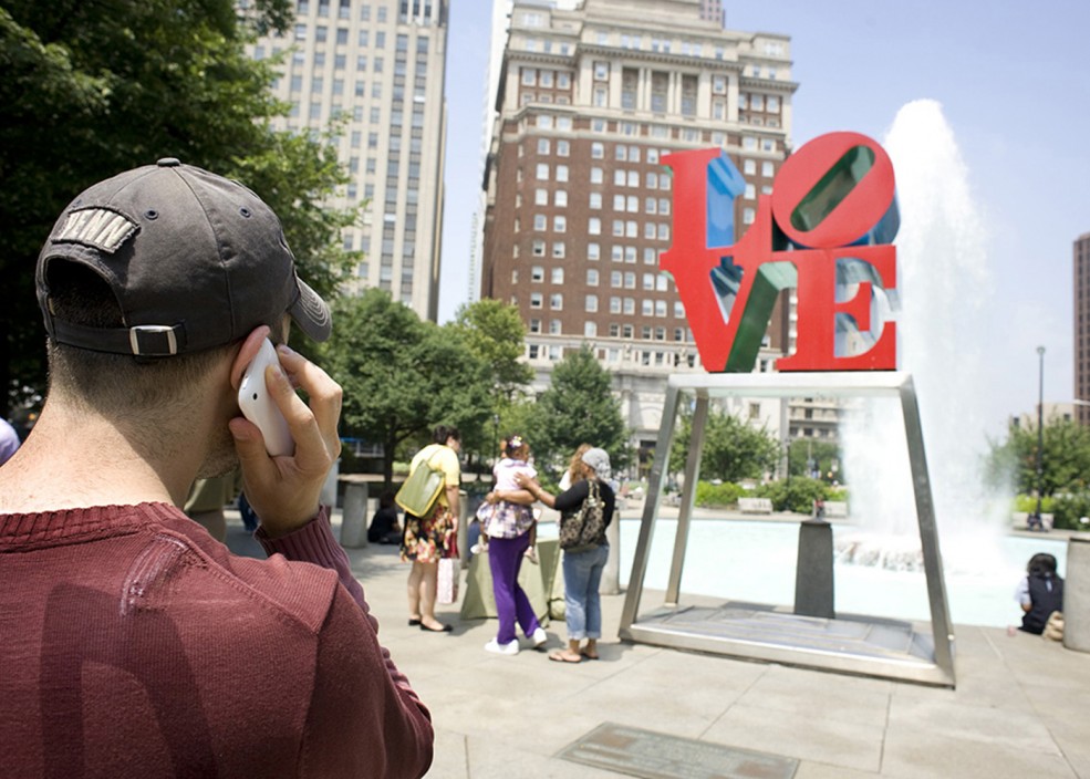 A user accesses the Museum Without Walls™: AUDIO program for Robert Indiana's <em>LOVE</em> sculpture on his cell phone. Photo Albert Yee © 2010 for Association for Public Art.