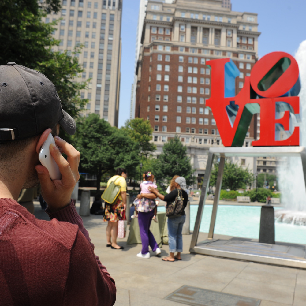 A listener hears about LOVE by Robert Indiana through museum without walls on his cell phone