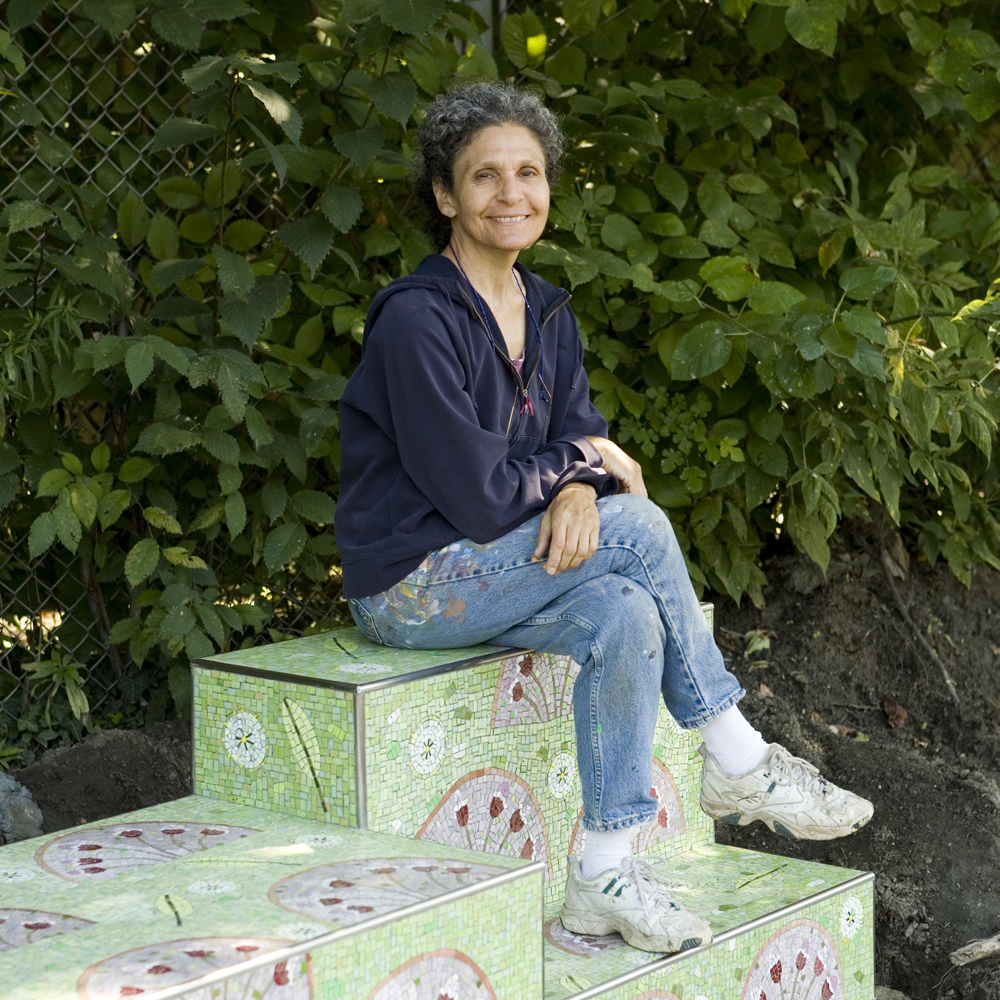 Artist Diane Pieri sits atop one of the stoops in her artwork, Manayunk Stoops