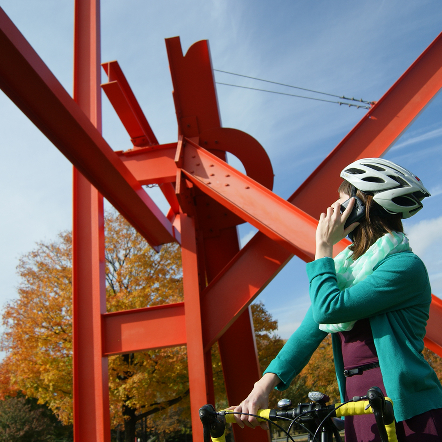A cyclist accesses Museum Without Walls by phone at the Iroquois sculpture