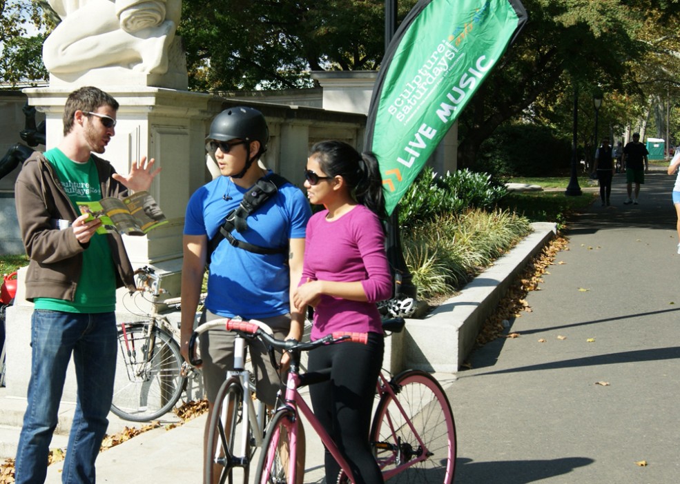 A Public Art Ambassador shows cyclists how to access aPA's Museum Without Walls™: AUDIO program. Photo Caitlin Martin © 2011 for the Association for Public Art.