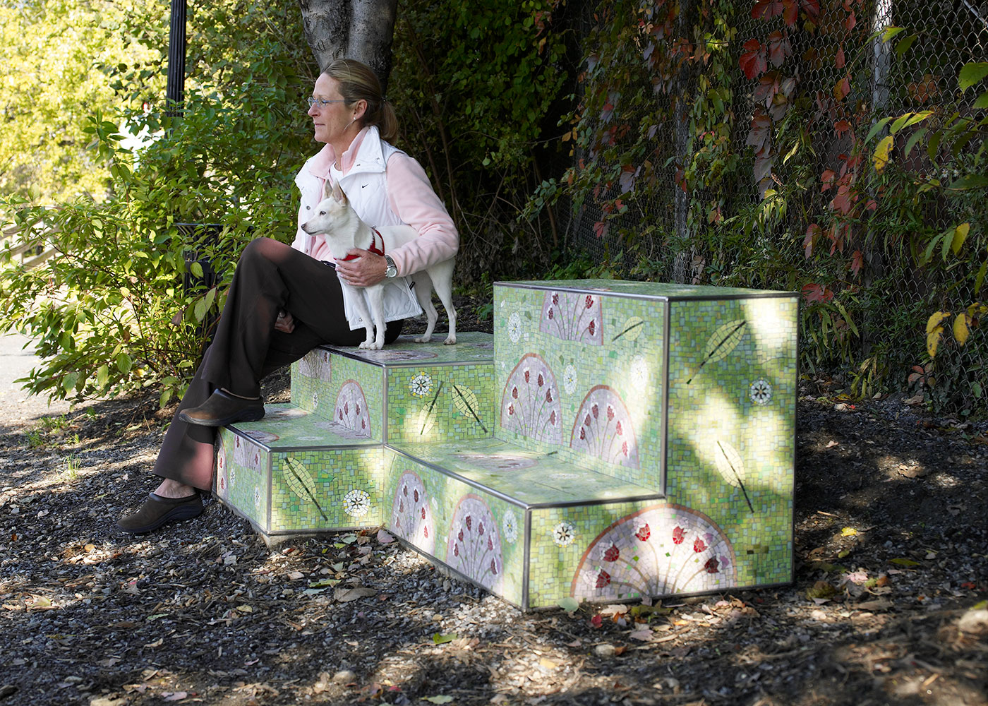 Woman and her dog sitting on Manayunk Stoops sculpture