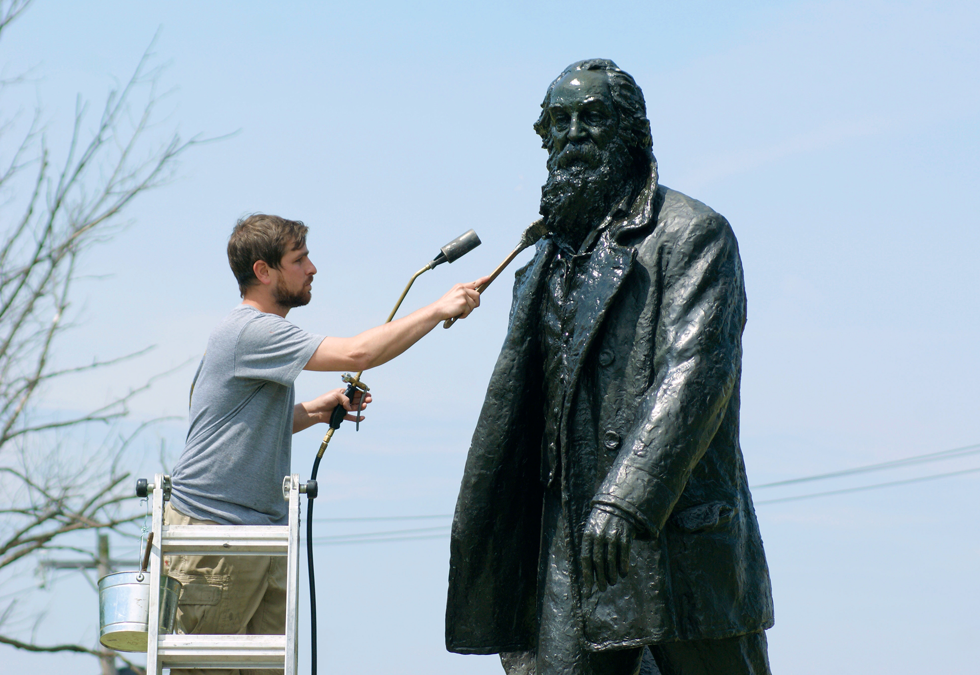 Conservators treating a bronze statue of Walt Whitman in south philadelphia