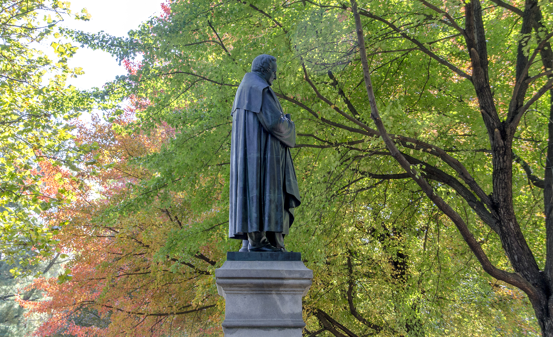 Statue of Alexander von Humboldt surrounded by green leaves in Philadelphia's Fairmount Park