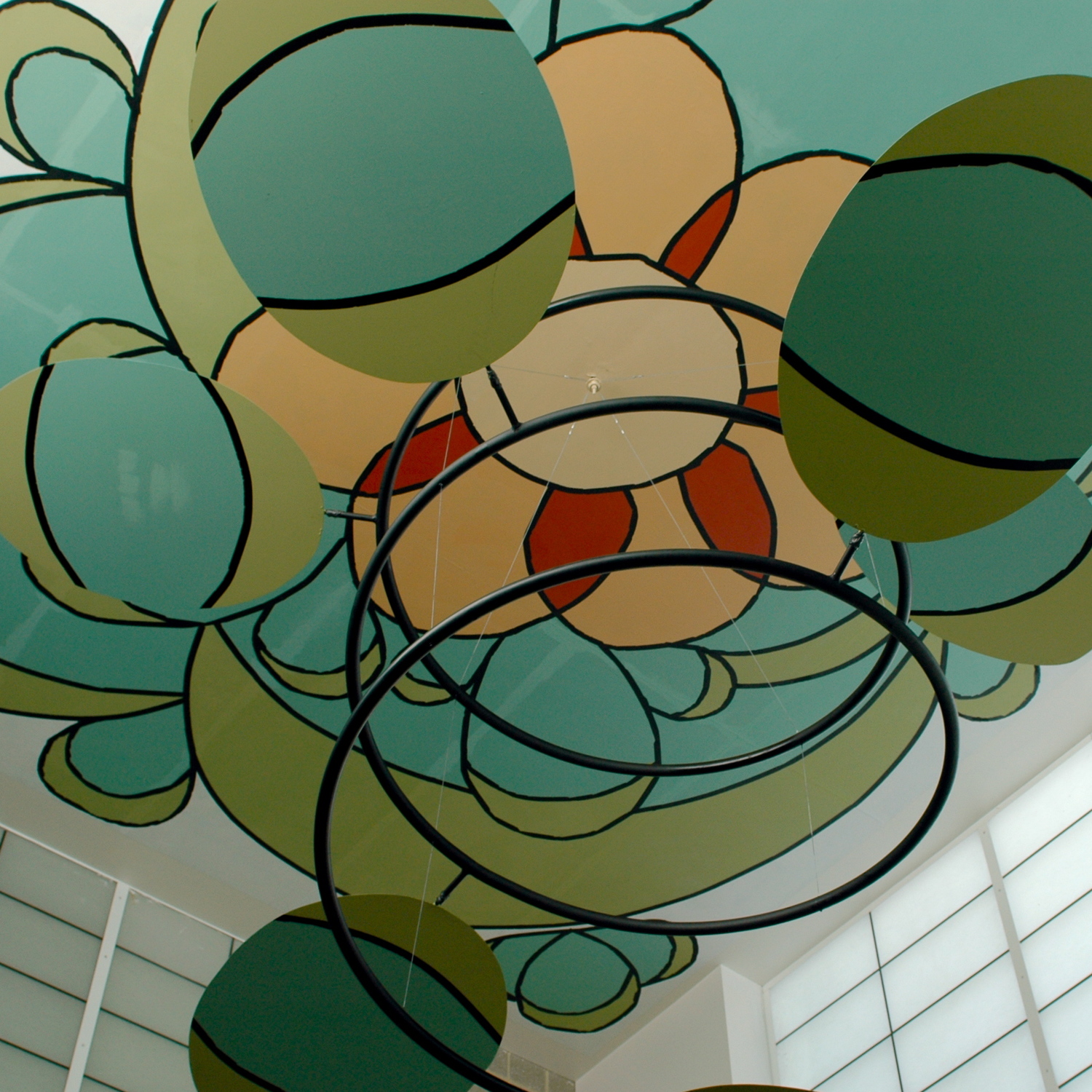 Colorful cartoon-like mural with hanging spiral mobiles on the ceiling