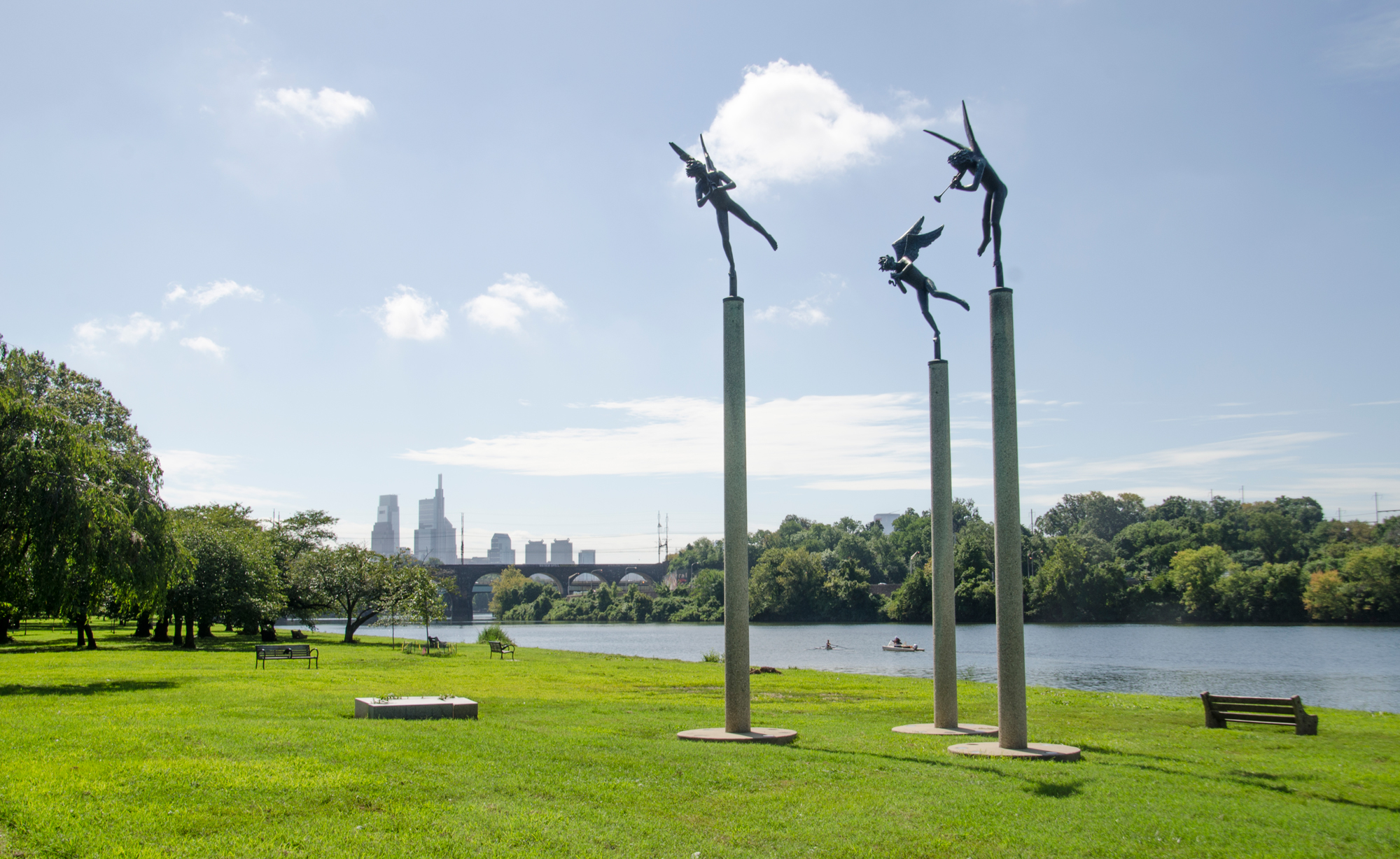 Angel sculptures with the Philadelphia skyline and Schuylkill River in the background