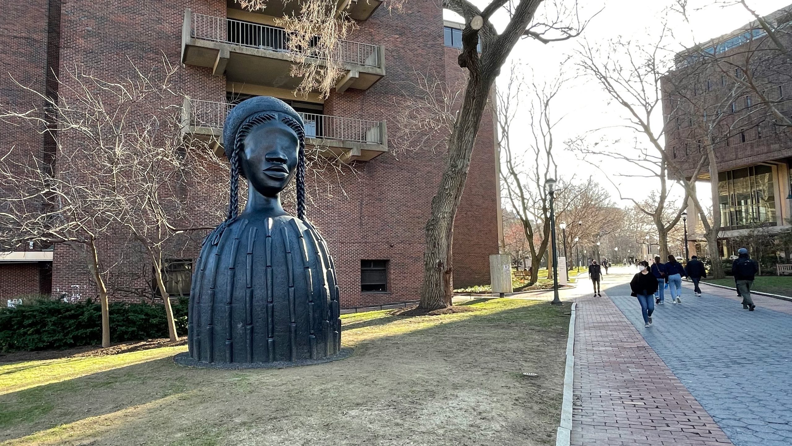 Simone Leigh's Brick House sculpture on Penn's campus with students walking nearby