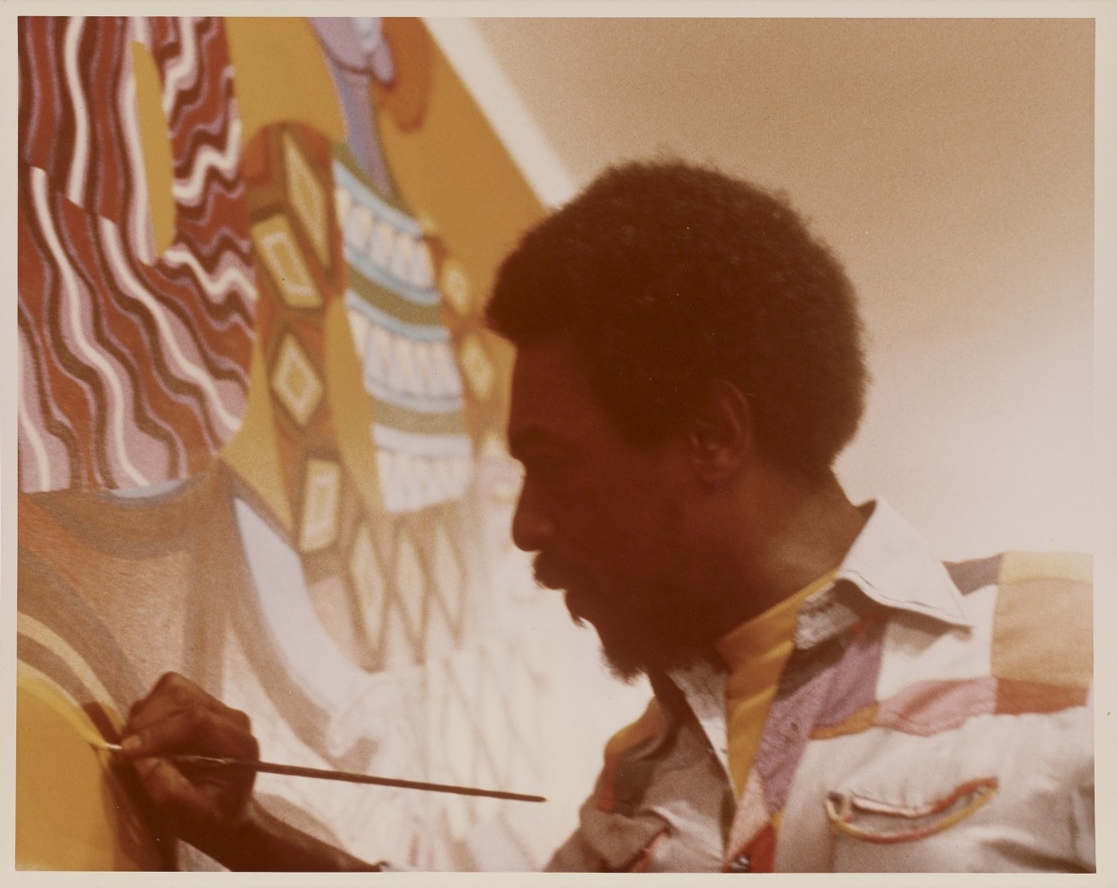 African American artist Charles Searles painting the Celebration mural, circa 1975.