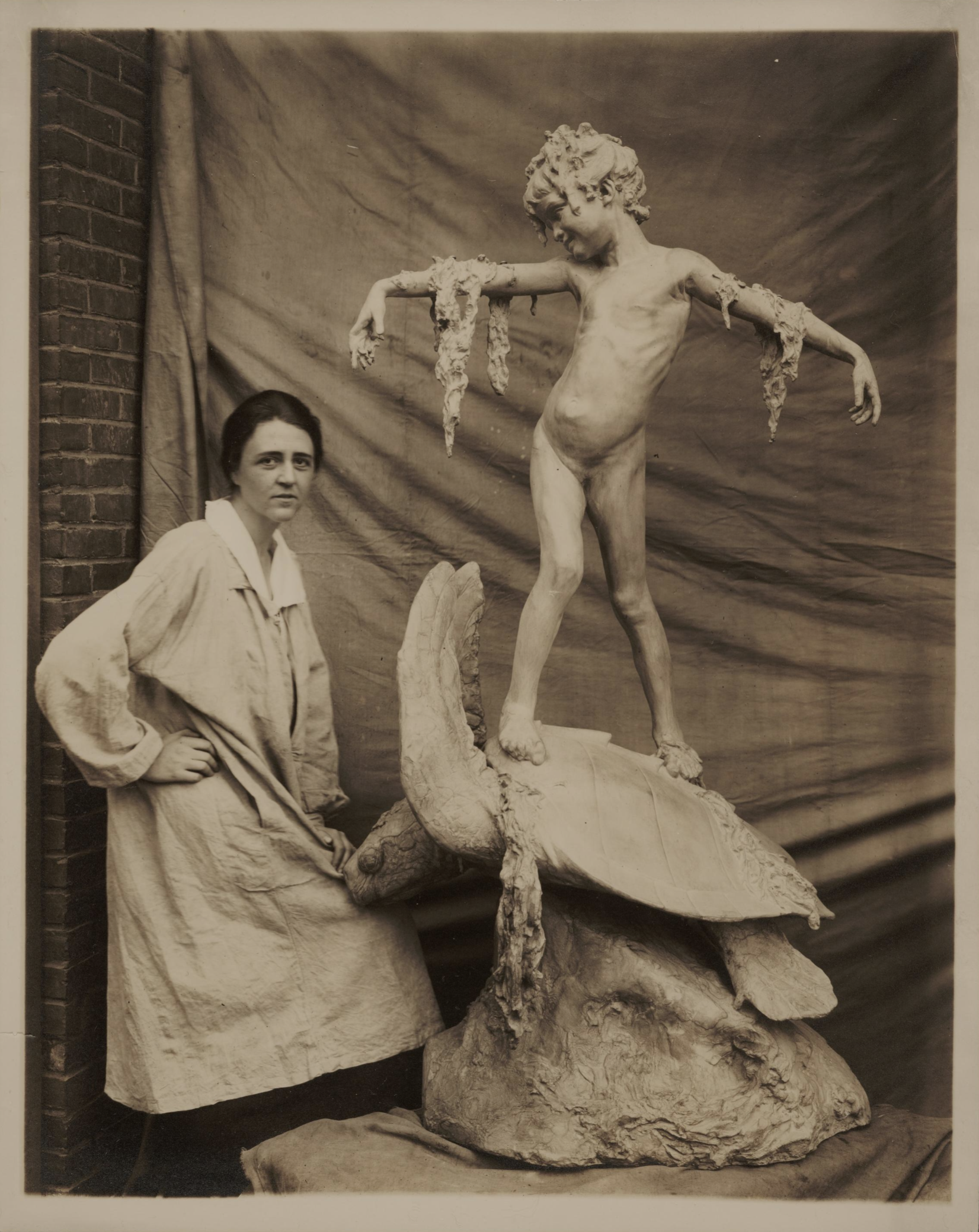 A black and white photo of sculptor Beatrice Fenton with her sculpture Seaweed Girl Fountain in the artist's studio